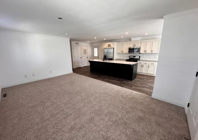 a living room with a couch and a view of kitchen