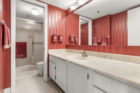 a bathroom with a toilet a sink and mirror