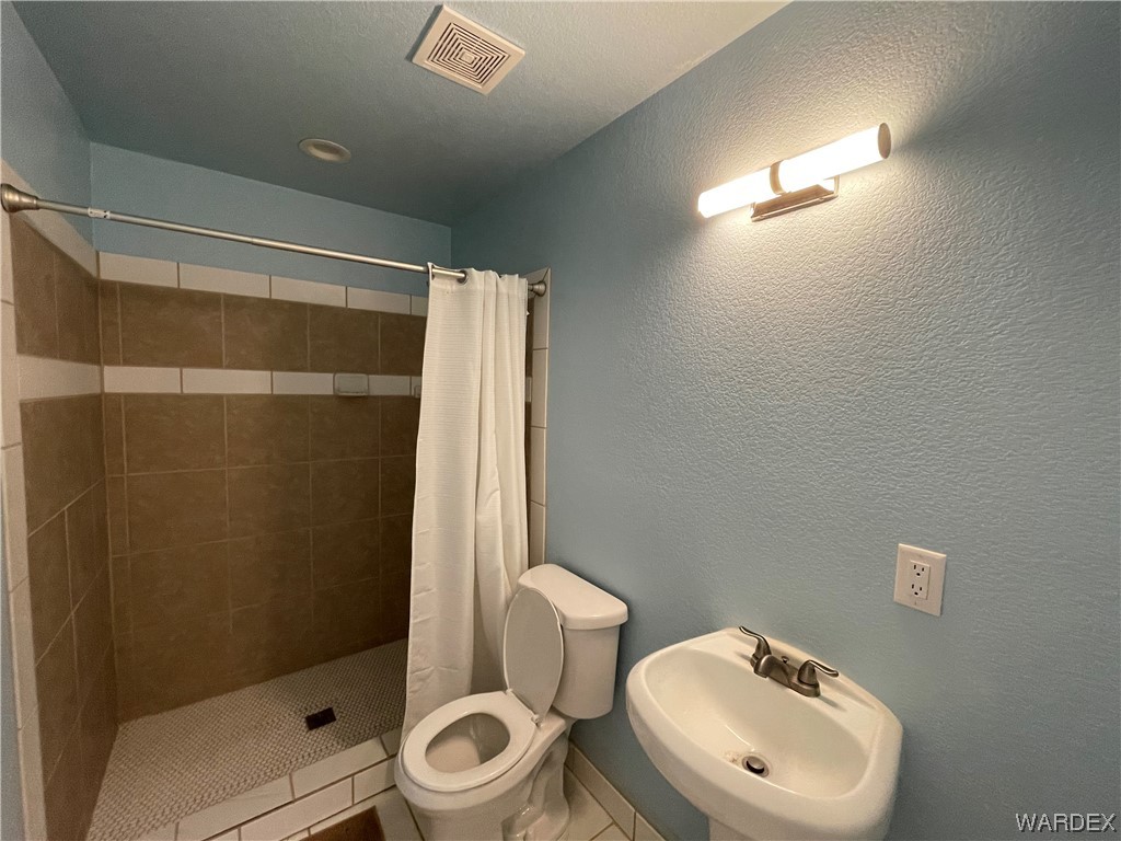 14438 Castle Butte Road Yucca, AZ 86438 - Photo 19 of 33 a bathroom with a toilet and a shower