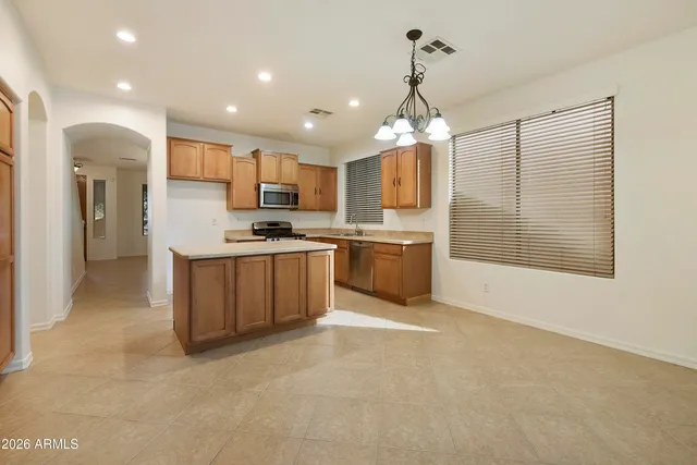 a large kitchen with kitchen island a sink a center island and stainless steel appliances