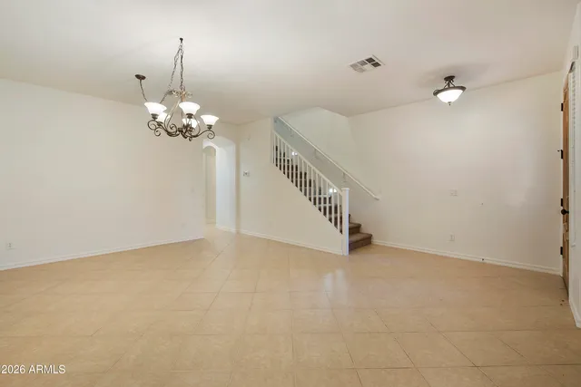 wooden floor in an empty room with a chandelier