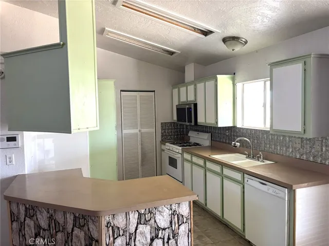a kitchen with a stove a sink and a refrigerator
