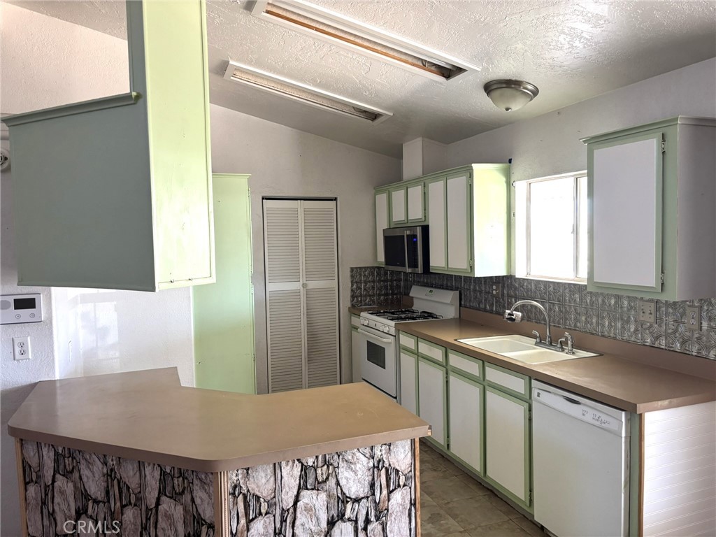20843 Waalew Road, Unit C4 Apple Valley, CA 92307 - Photo 11 of 38 a kitchen with a stove a sink and a refrigerator