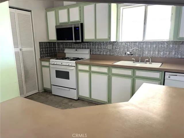 a kitchen with a sink stove and cabinets