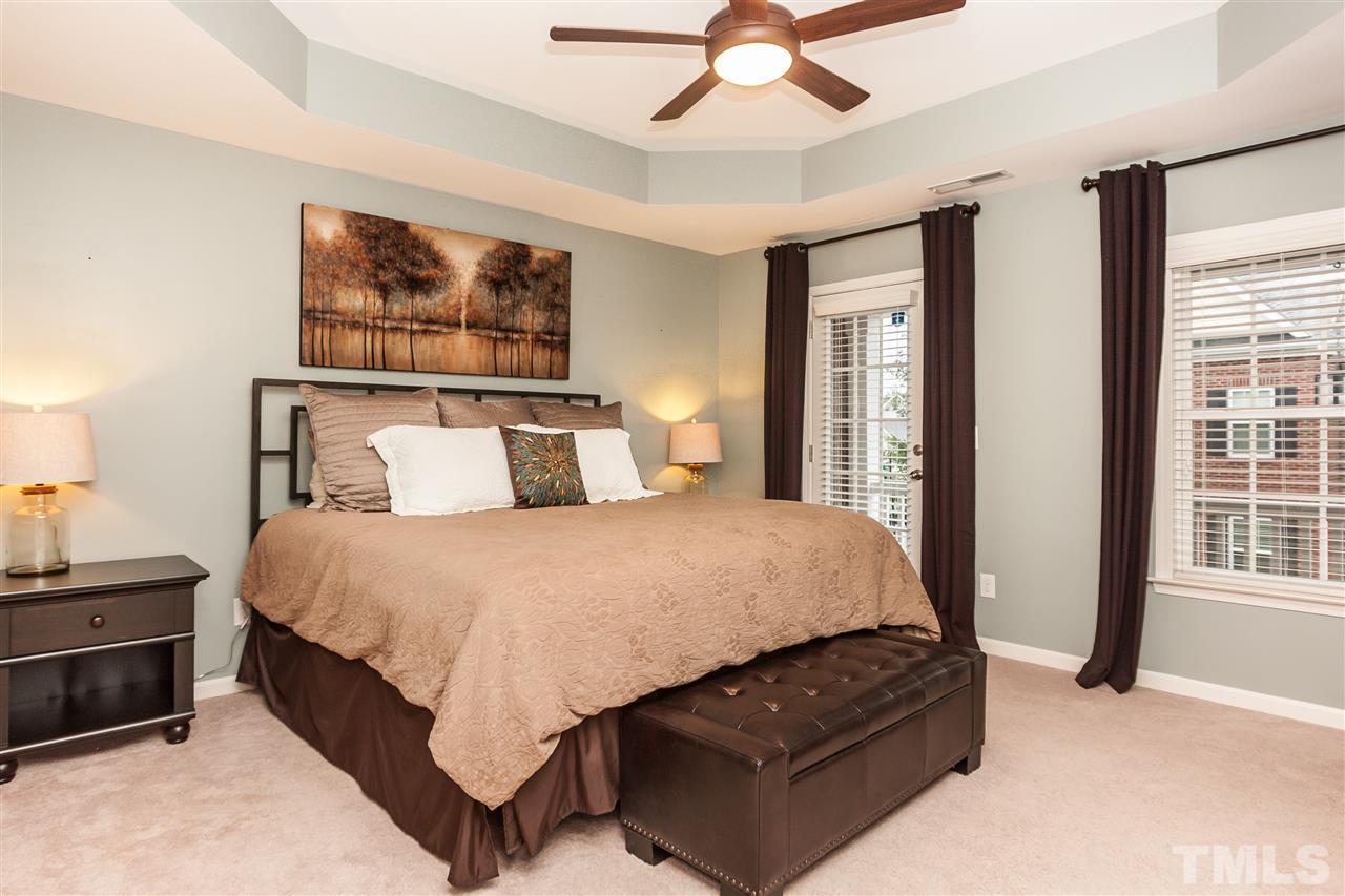 1306 Still Monument Way Raleigh, NC 27603 - Photo 11 of 25 a large bed sitting in a bedroom next to a window and a chandelier