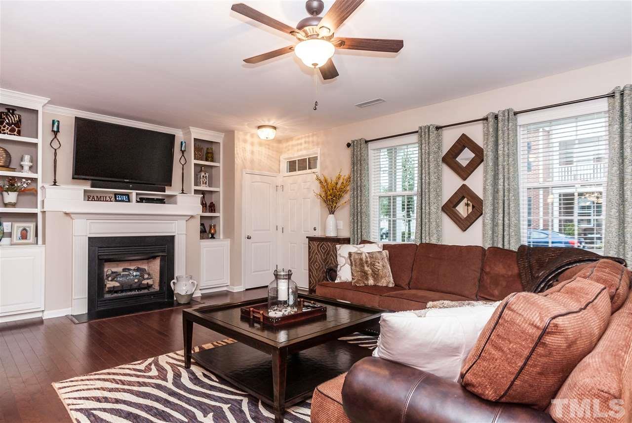 1306 Still Monument Way Raleigh, NC 27603 - Photo 3 of 25 a living room with furniture a fireplace and a flat screen tv