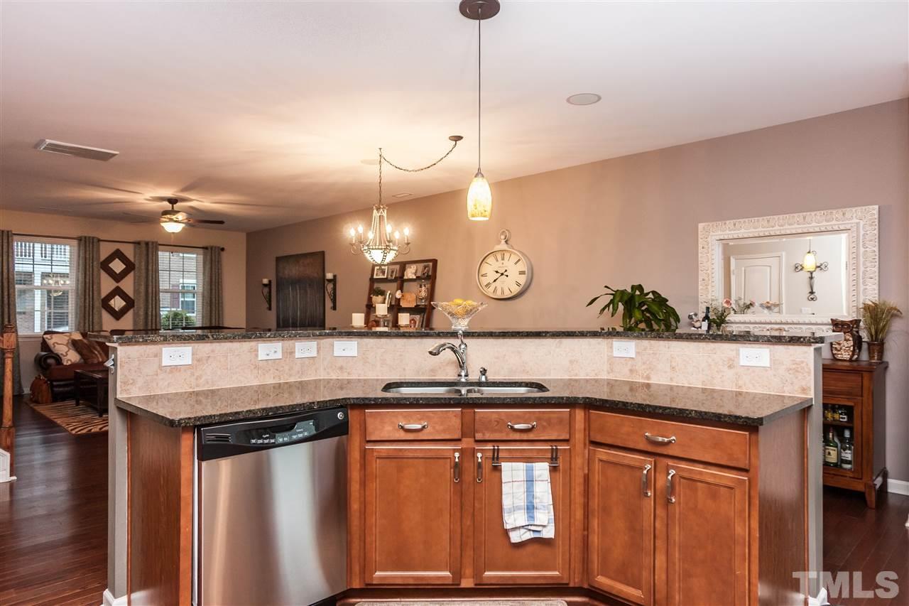 1306 Still Monument Way Raleigh, NC 27603 - Photo 24 of 25 a kitchen with granite countertop a sink a counter top space and living room view