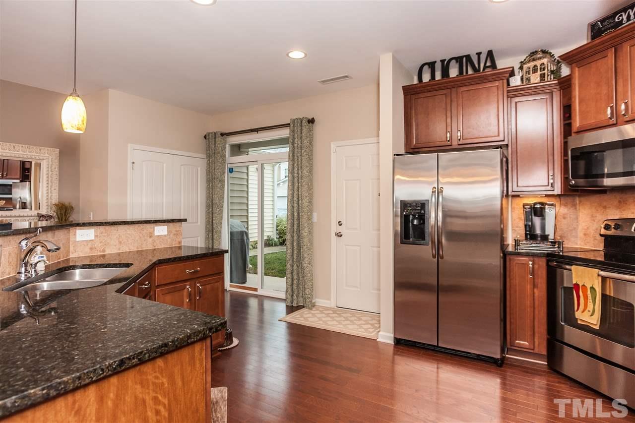1306 Still Monument Way Raleigh, NC 27603 - Photo 8 of 25 a kitchen with stainless steel appliances granite countertop a sink a stove and a refrigerator