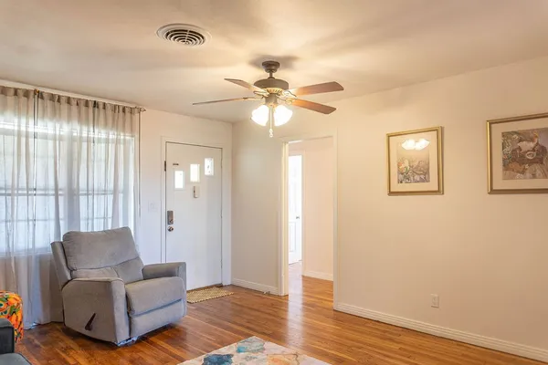 a living room with furniture and a ceiling fan