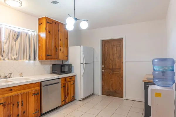 a kitchen with stainless steel appliances granite countertop a refrigerator a sink and dishwasher