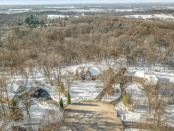 a front view of a house with a yard covered in snow