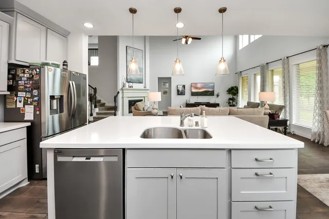 a kitchen with stainless steel appliances a sink a stove a refrigerator and cabinets