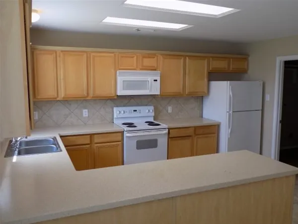 a kitchen with a cabinets and white appliances