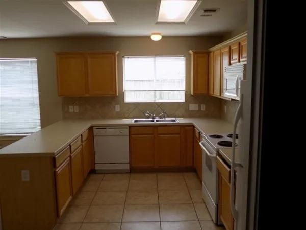 a kitchen with a stove sink and cabinets