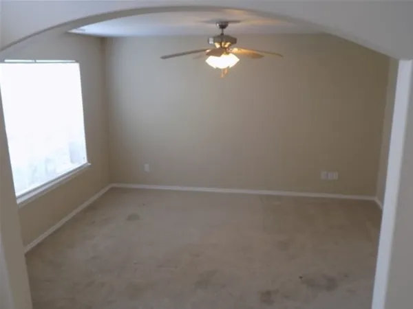 a view of a windows and chandelier fan in big room