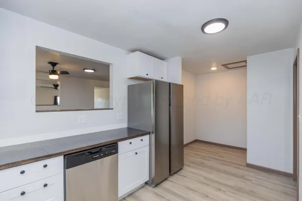 a kitchen with stainless steel appliances a refrigerator and wooden floor