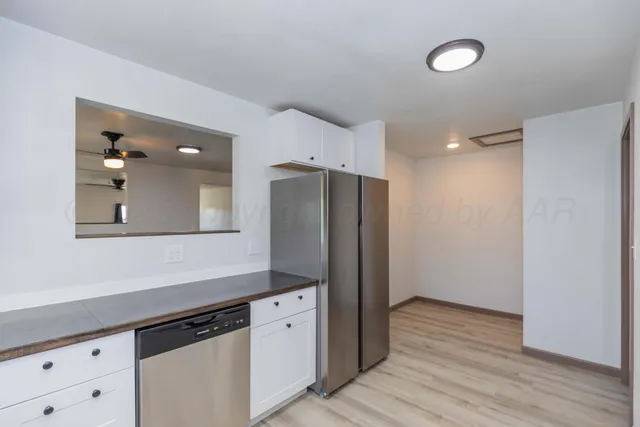 a kitchen with stainless steel appliances a refrigerator and wooden floor