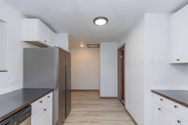 a kitchen with stainless steel appliances granite countertop a refrigerator and a sink
