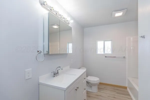 a bathroom with a toilet a sink and mirror