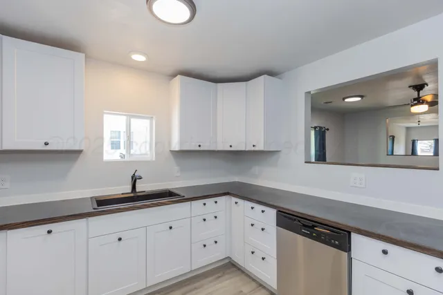 a kitchen with granite countertop white cabinets and a sink