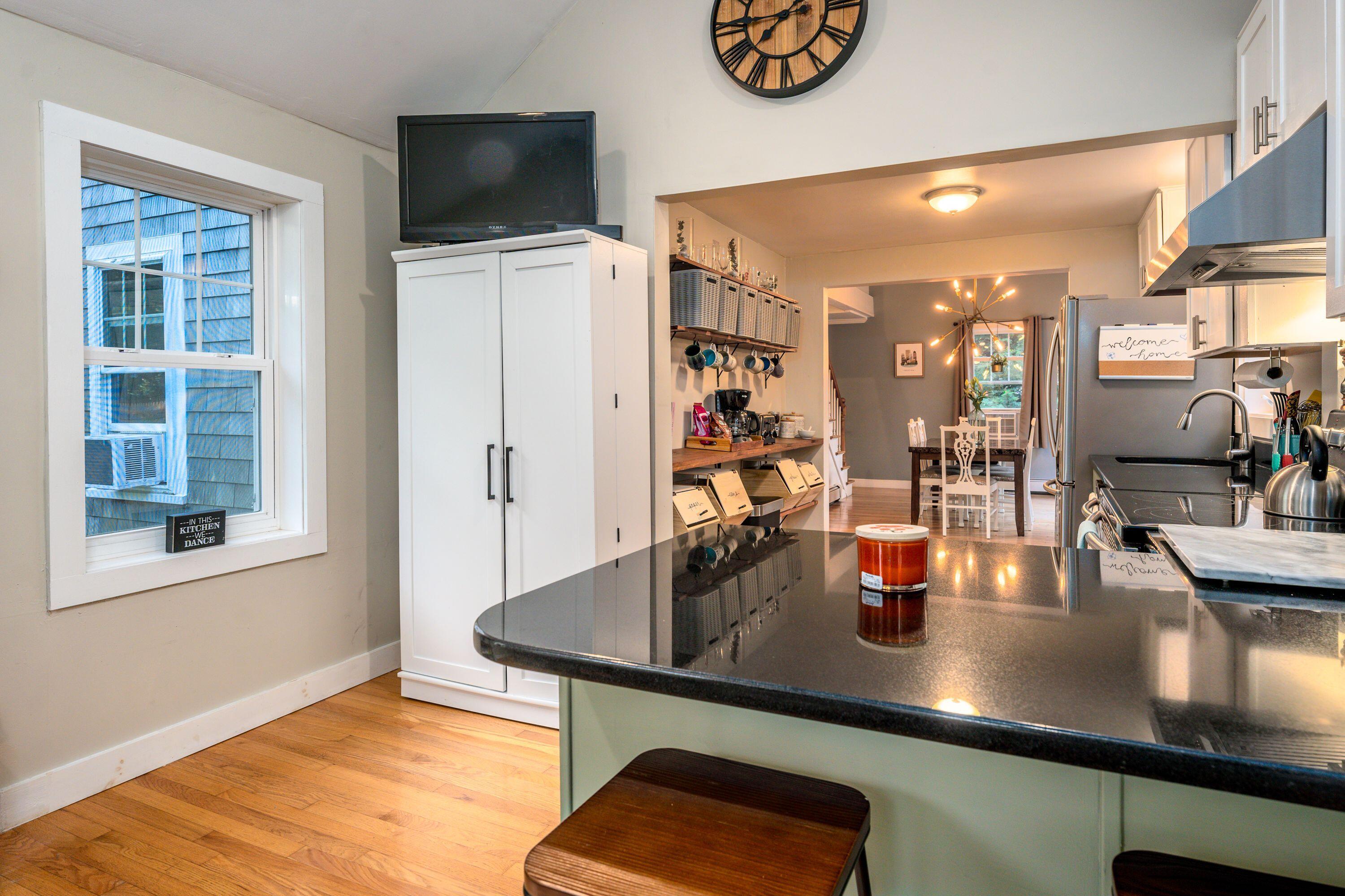 171 Cap'n Lijah's Road Centerville, MA 02632 - Photo 13 of 31 a dining table with wooden floor and kitchen view