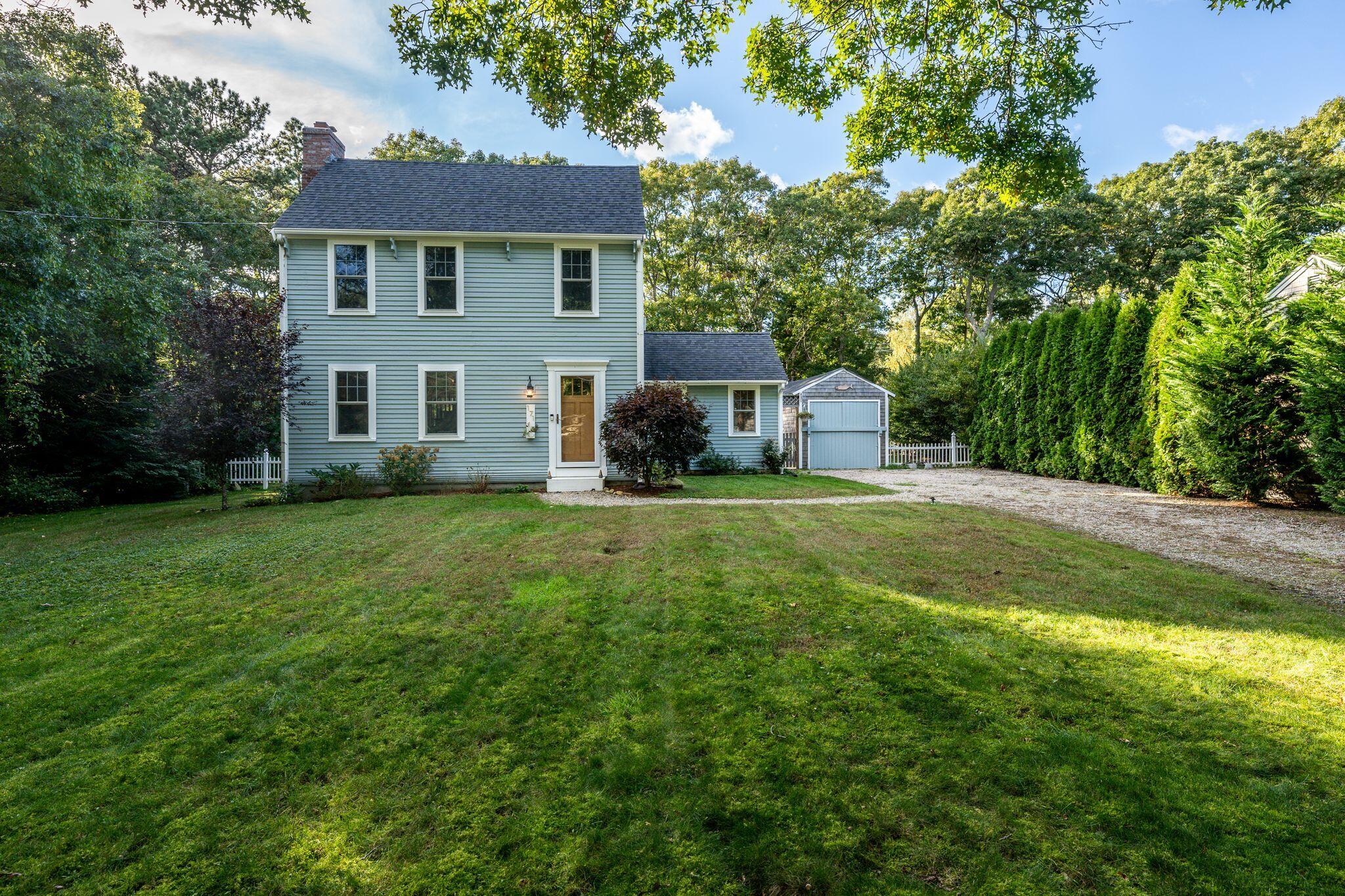 171 Cap'n Lijah's Road Centerville, MA 02632 - Photo 29 of 31 a house that is sitting in the grass with tress in the background
