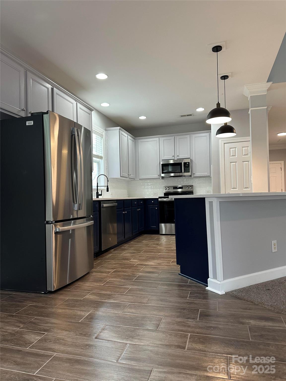 18705 The Commons Boulevard Cornelius, NC 28031 - Photo 3 of 19 a kitchen with granite countertop a refrigerator and a stove top oven