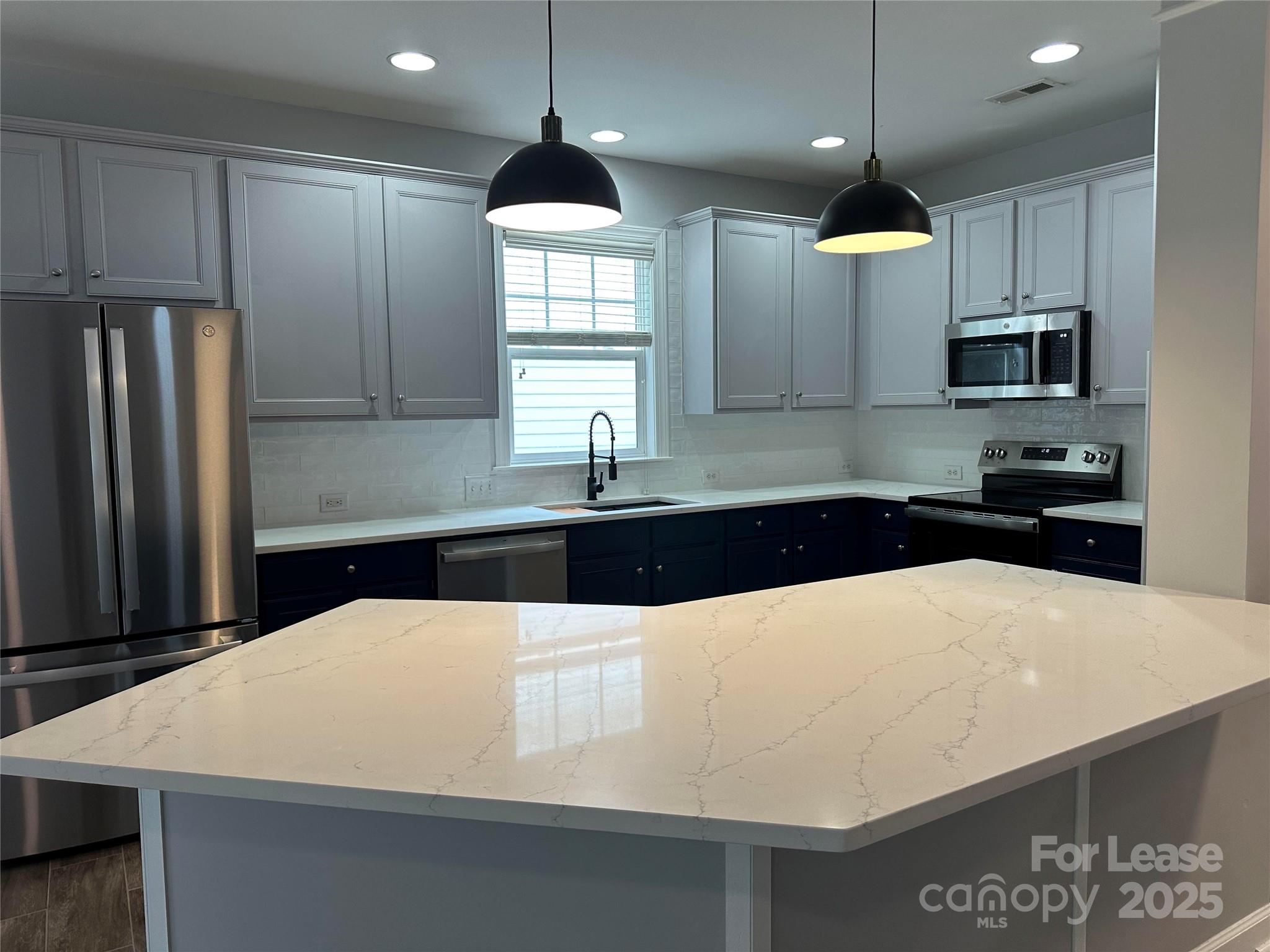 18705 The Commons Boulevard Cornelius, NC 28031 - Photo 4 of 19 a kitchen with stainless steel appliances a sink a stove a refrigerator and cabinets