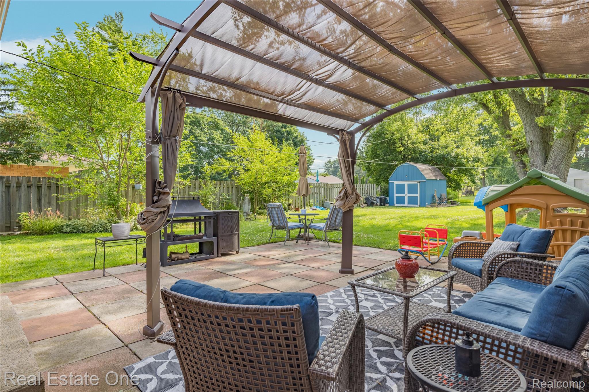 2810 Walbridge Drive Rochester, MI 48307 - Photo 42 of 58 Paver patio featuring a covered pergola, a built-in outdoor cooking station, and a manicured lawn