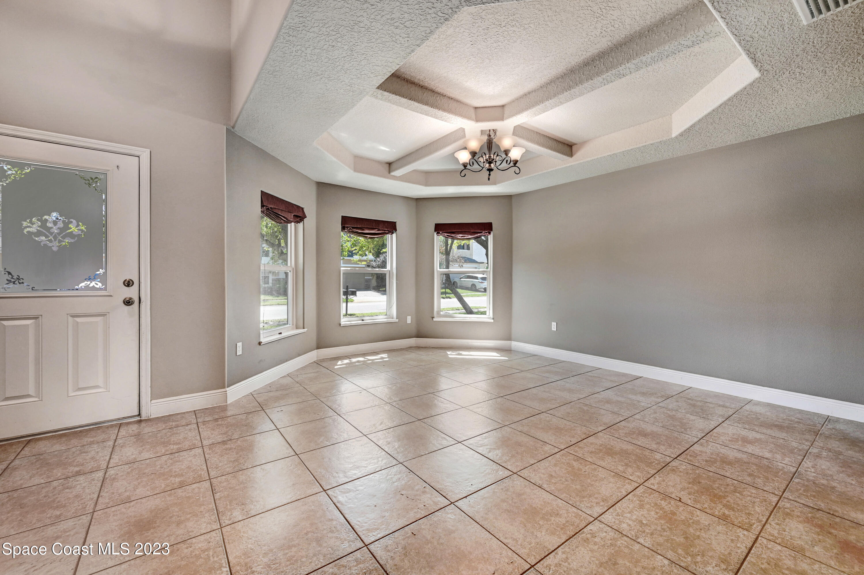 1202 Becket Place Melbourne, FL 32940 - Photo 7 of 56 a view of an empty room with a chandelier