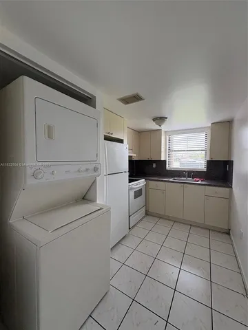 a kitchen with cabinets and white appliances