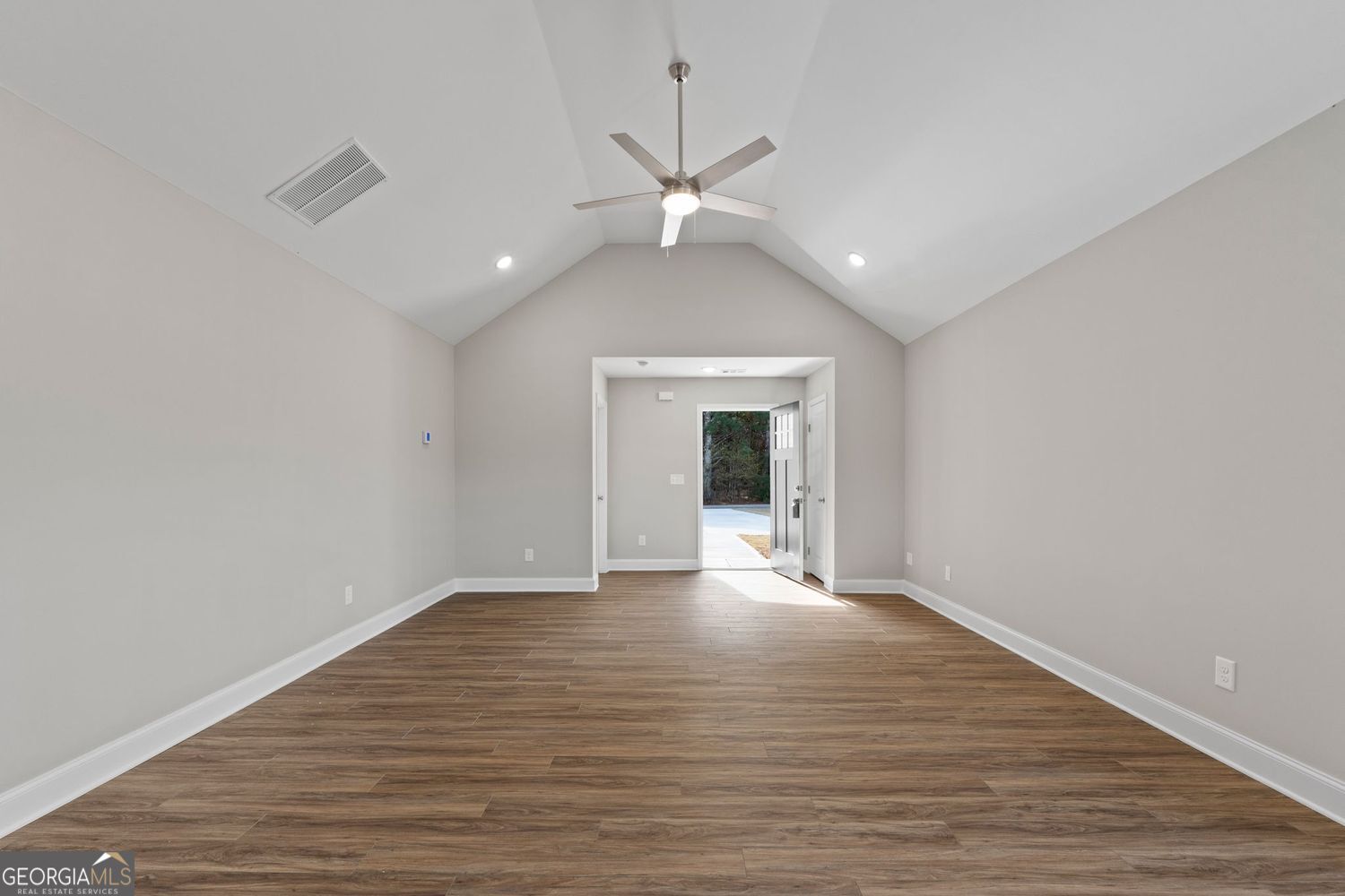 166 Mathews Road Milner, GA 30257 - Photo 7 of 32 a view of an empty room with wooden floor and a ceiling fan