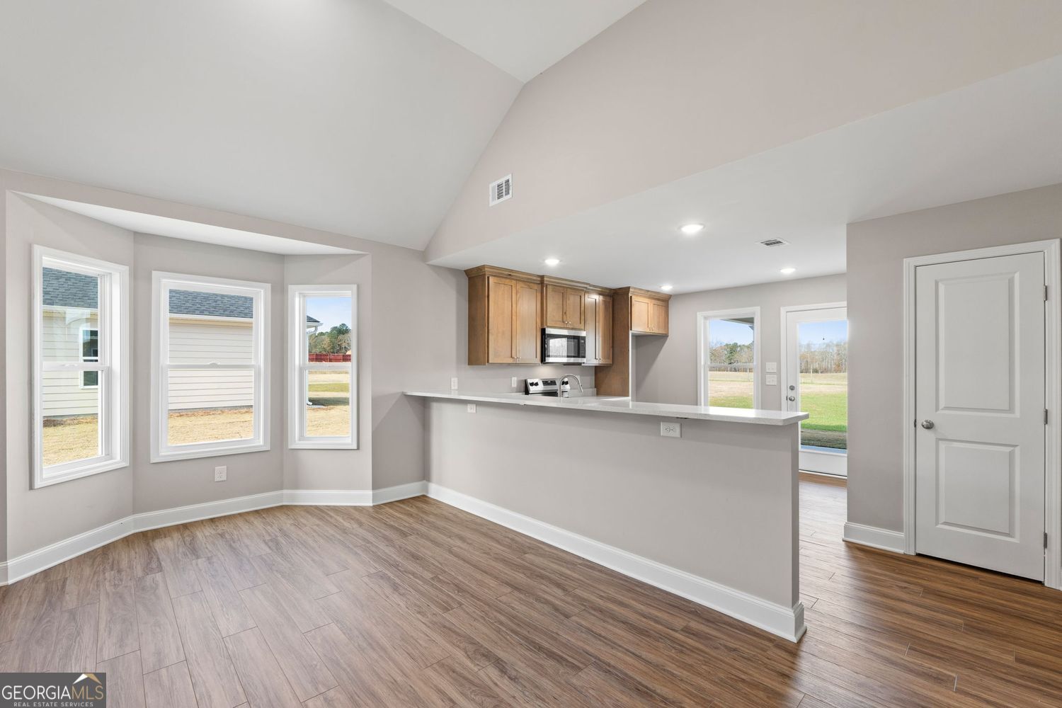 166 Mathews Road Milner, GA 30257 - Photo 9 of 32 an open kitchen with wooden floor and windows