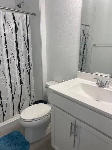 a white toilet sitting next to a bathroom sink