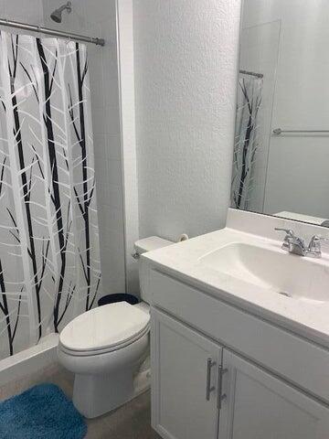5133 Armina Place, Unit STUDIO Fort Pierce, FL 34951 - Photo 8 of 18 a white toilet sitting next to a bathroom sink