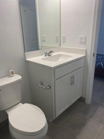 5133 Armina Place, Unit STUDIO Fort Pierce, FL 34951 - Photo 9 of 18 a bathroom with a sink mirror vanity and toilet