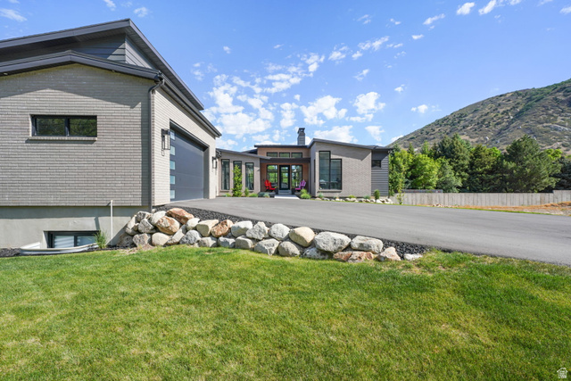 3667 Little Cottonwood Road, Unit 1 Sandy, UT 84092 - Photo 2 of 49 Modern architectural residence featuring multi-tone brick and siding, a multi-pane garage door, and a paved driveway with a natural rock border
