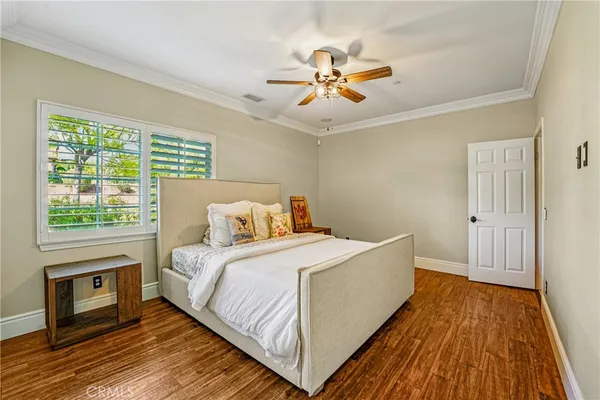 a spacious bedroom with a bed and wooden floor