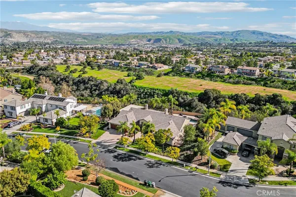 an aerial view of a house with swimming pool and a yard