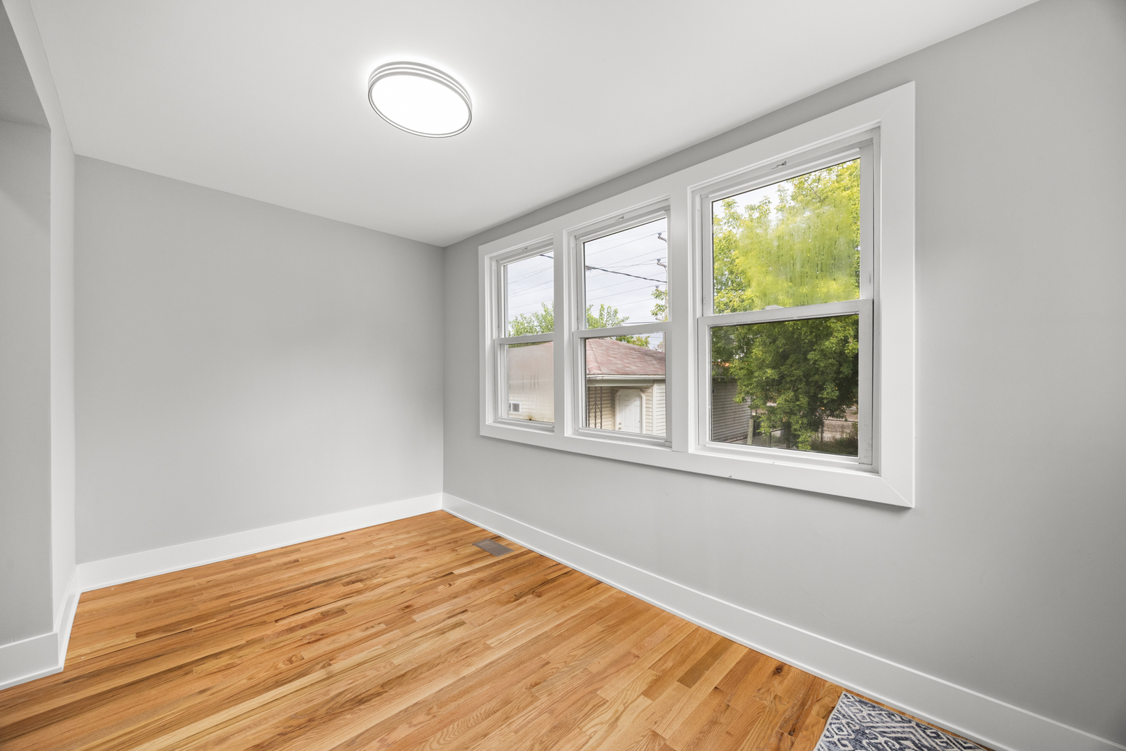 21 East 140th Court Riverdale, IL 60827 - Photo 8 of 29 an empty room with wooden floor and windows