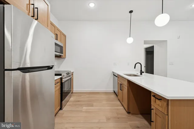 a kitchen with granite countertop a sink a counter space and cabinets