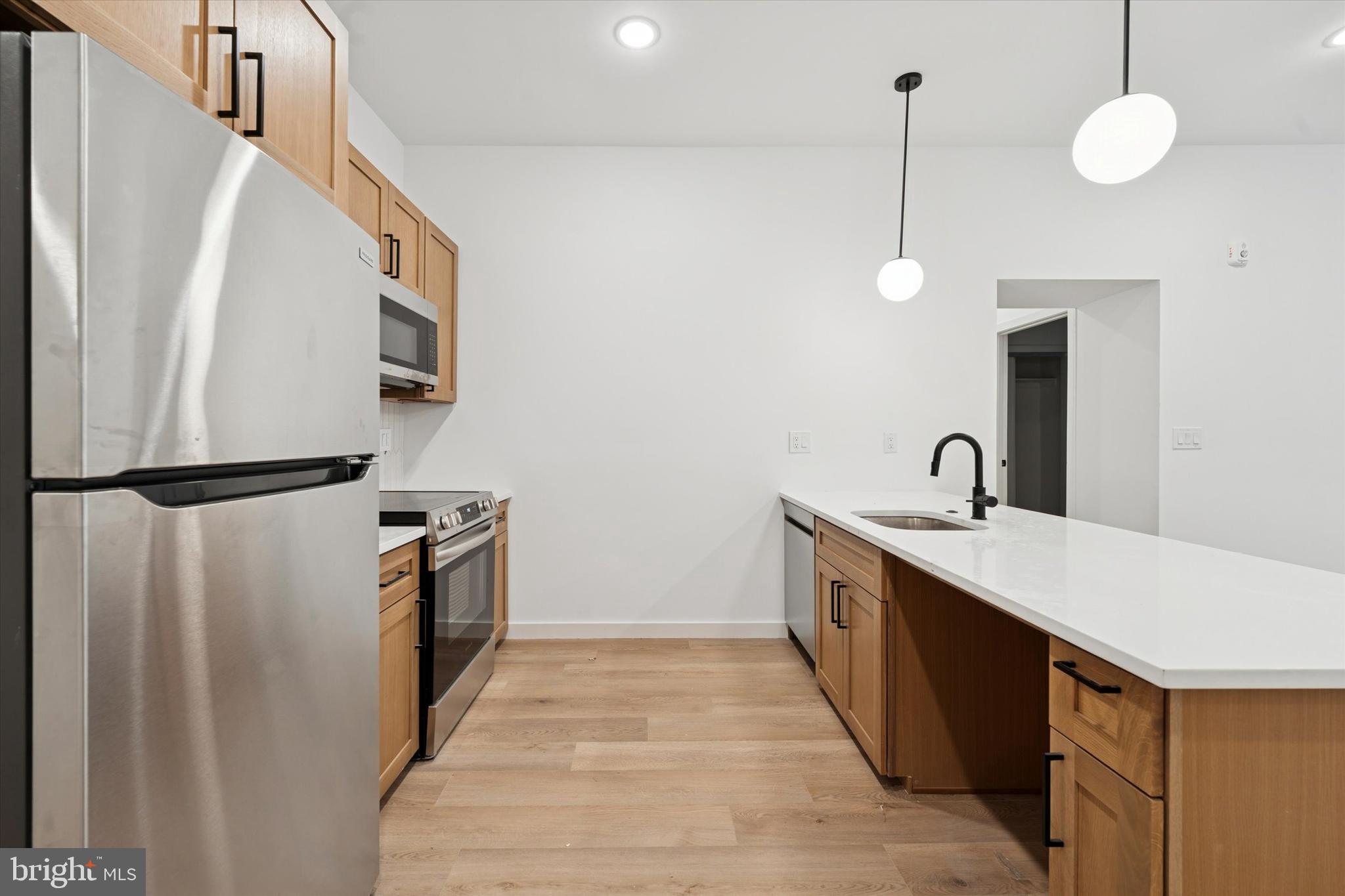 754 South 4th Street, Unit 101 Philadelphia, PA 19147 - Photo 4 of 14 a kitchen with granite countertop a sink a counter space and cabinets