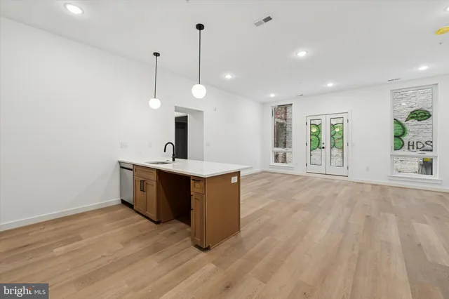 a view of a kitchen with a sink wooden floor and a window
