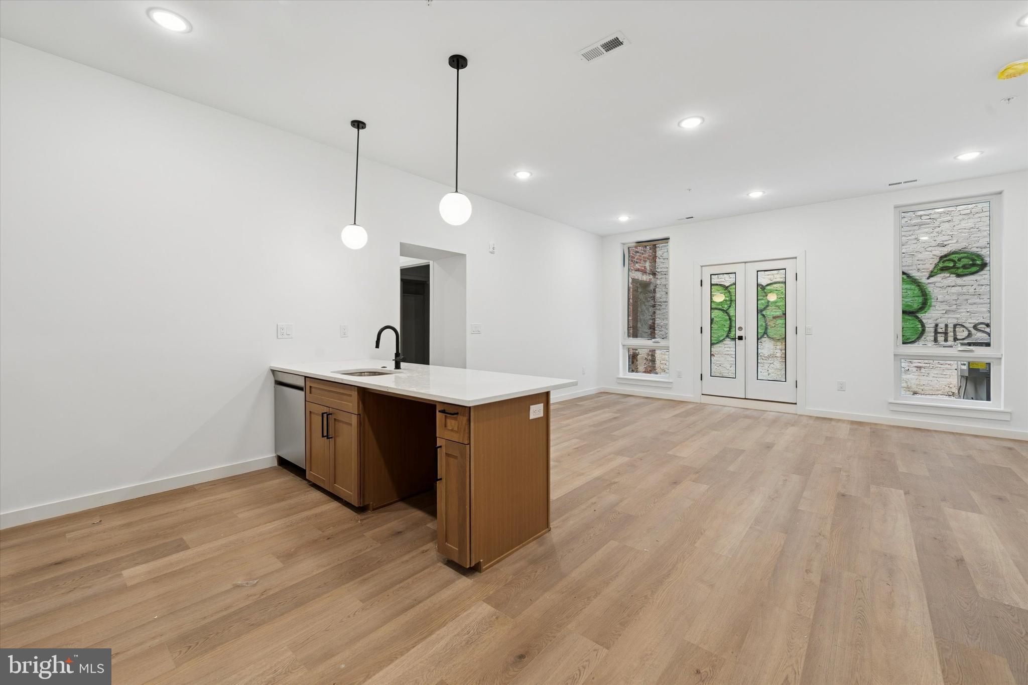 754 South 4th Street, Unit 101 Philadelphia, PA 19147 - Photo 5 of 14 a view of a kitchen with a sink wooden floor and a window