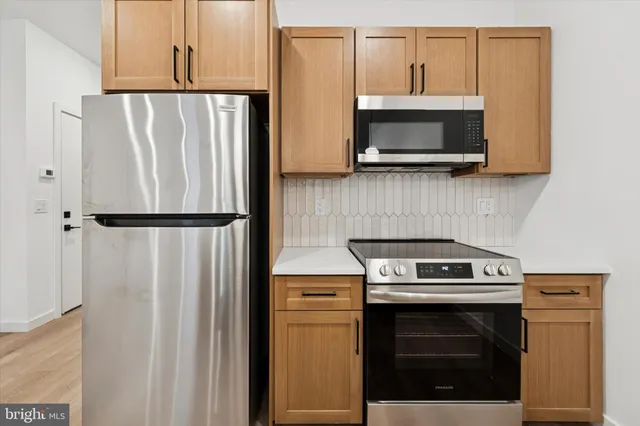 a kitchen with stainless steel appliances wooden floor sink and stove