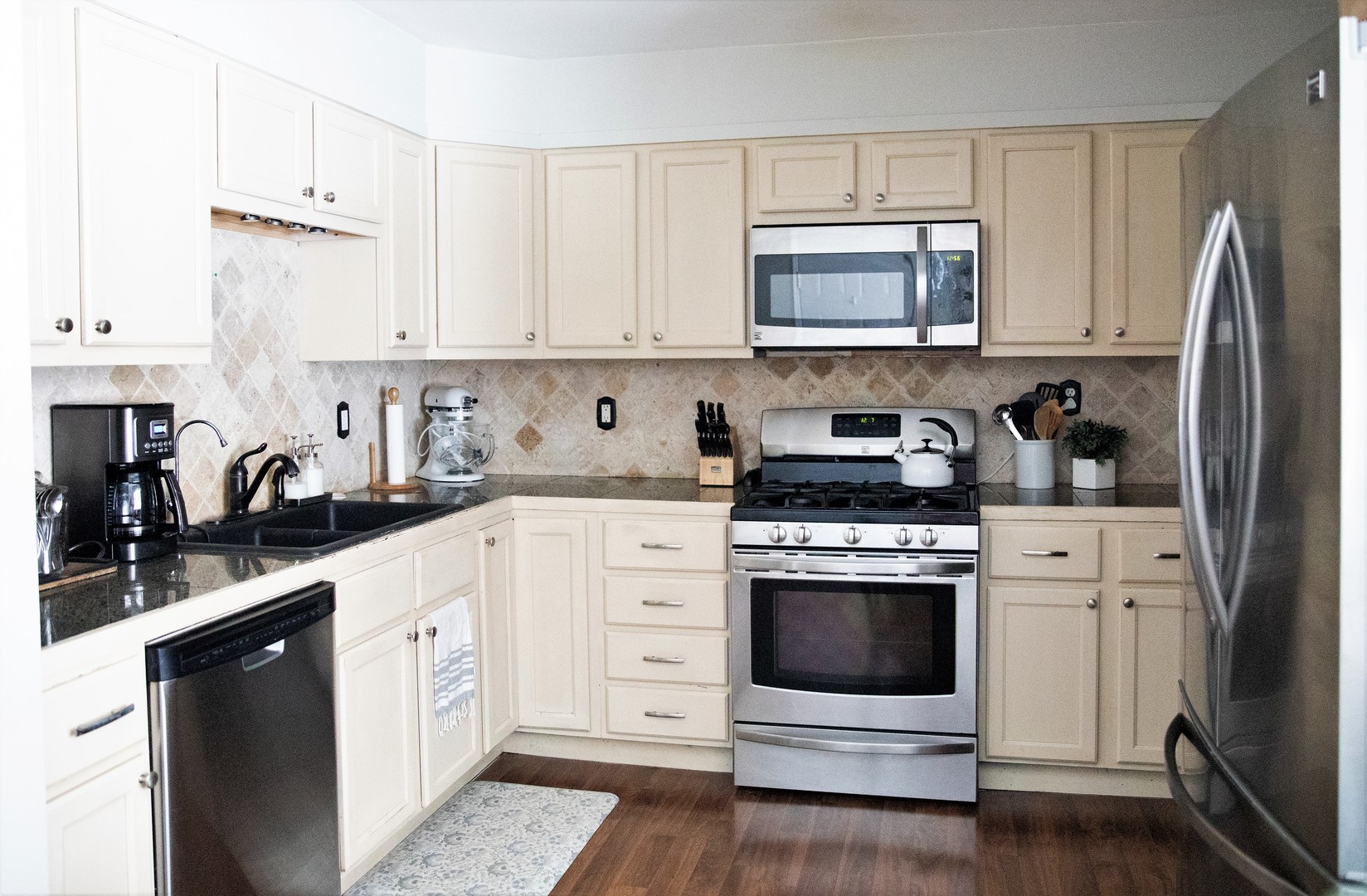 2119 Fairfield Road Lindenhurst, IL 60046 - Photo 7 of 22 a kitchen with cabinets stainless steel appliances a sink and wooden floor
