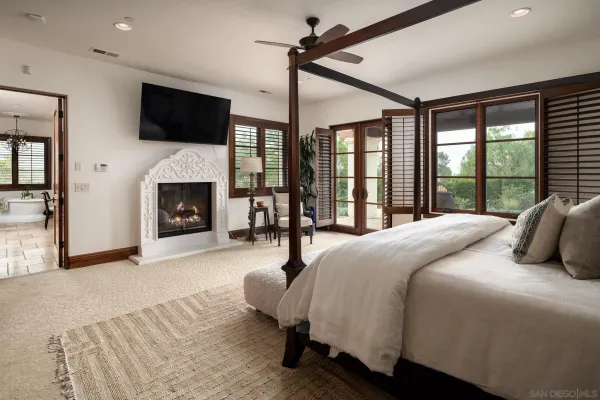 a bedroom with a large bed and a fireplace