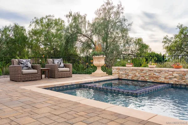 swimming pool with outdoor seating and green space