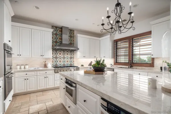 a kitchen with stainless steel appliances granite countertop a sink a stove cabinets counter space and a window