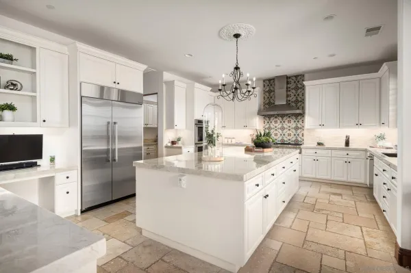 a kitchen with stainless steel appliances kitchen island granite countertop a sink and refrigerator